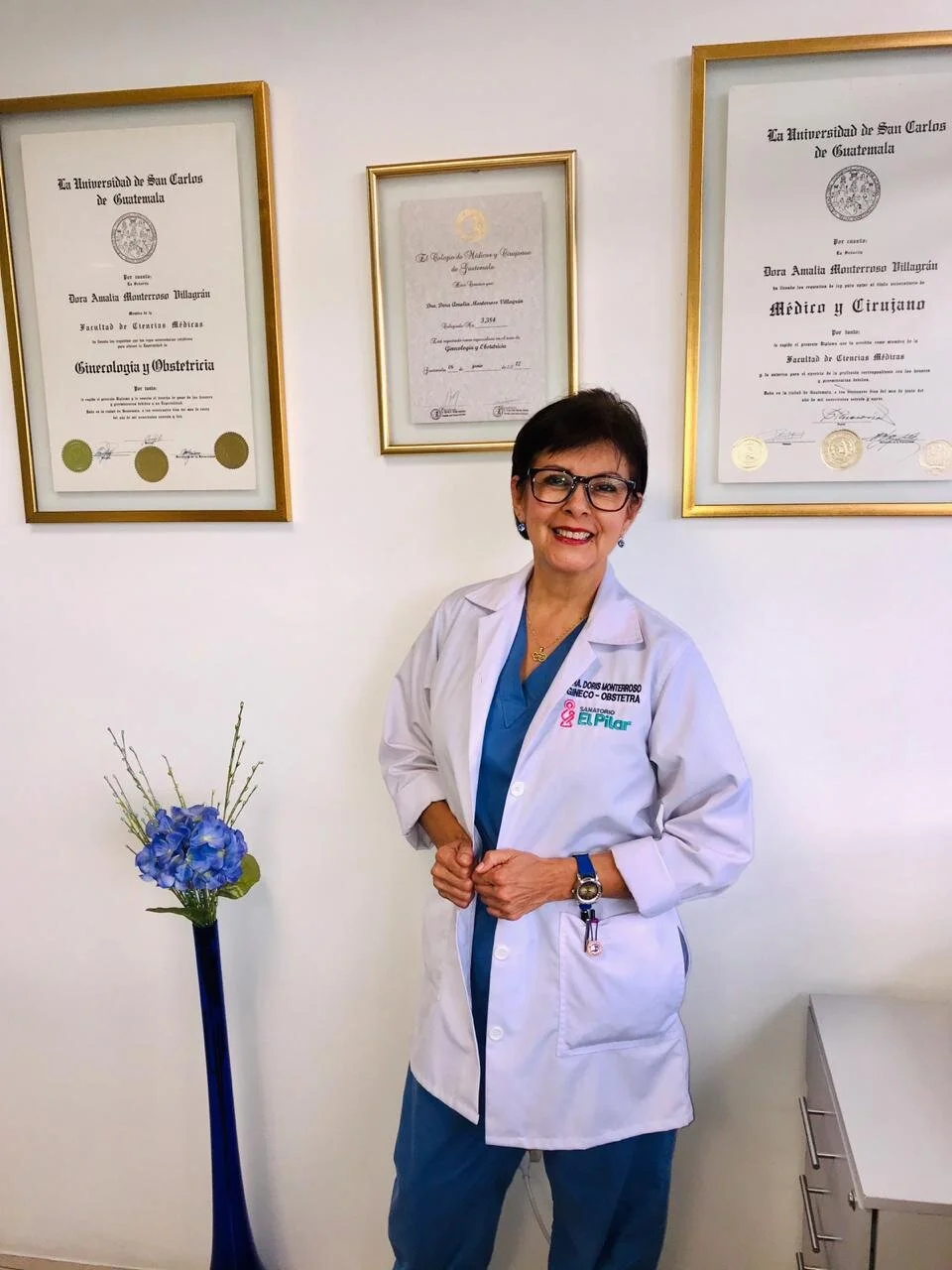 Dra. Doris Monterroso en su clínica junto a sus diplomas de la Universidad de San Carlos de Guatemala